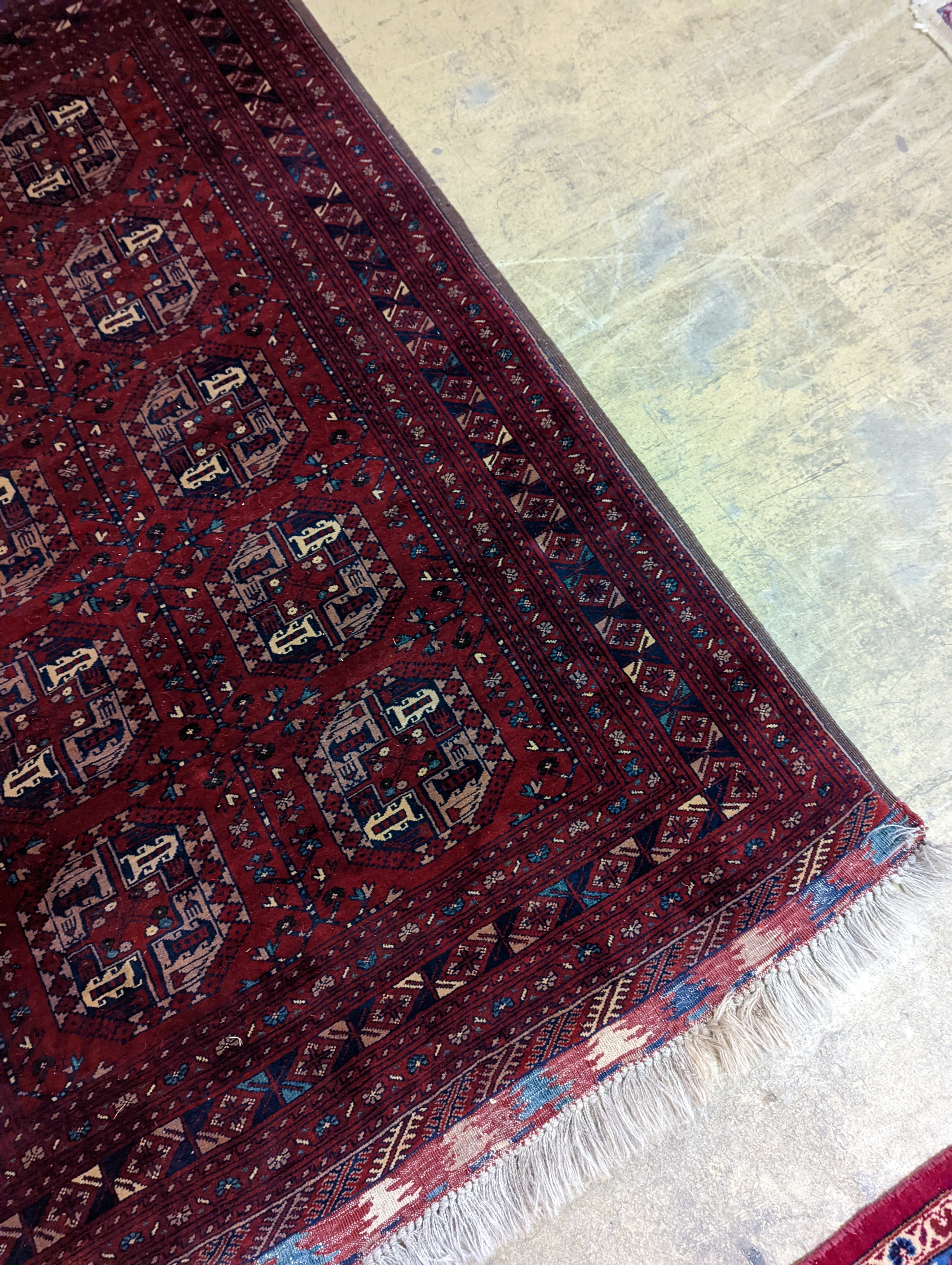 A Belouch red ground rug woven with octagonal motifs, 190 x 124 cms.
